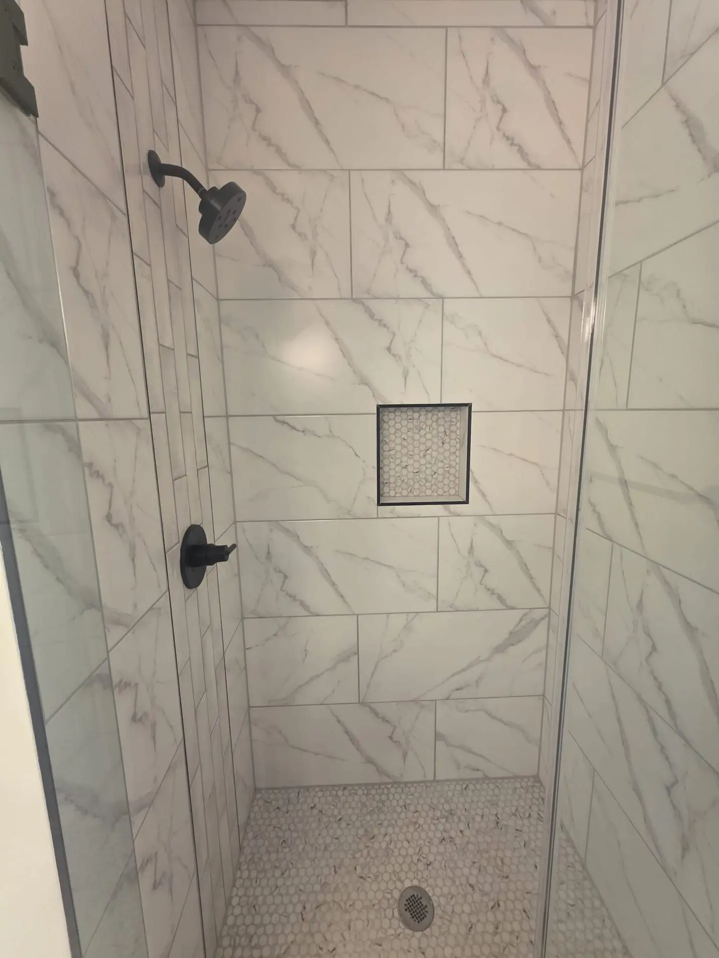 Curbless walk-in shower in honed stone