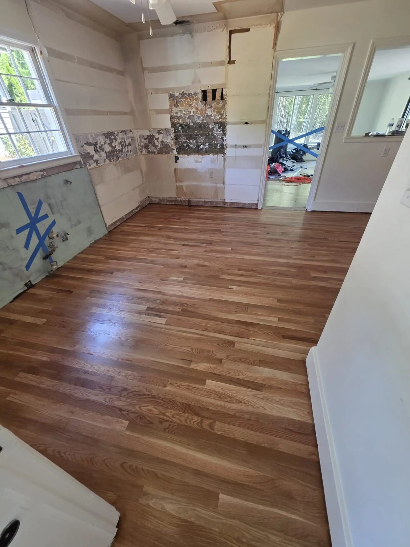 Freshly installed oak-tone flooring in a room still under renovation
